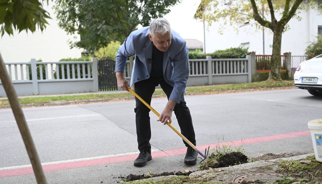 FOTO in VIDEO: Primc po vložitvi kandidature cestne odtoke čistil kar v obleki
