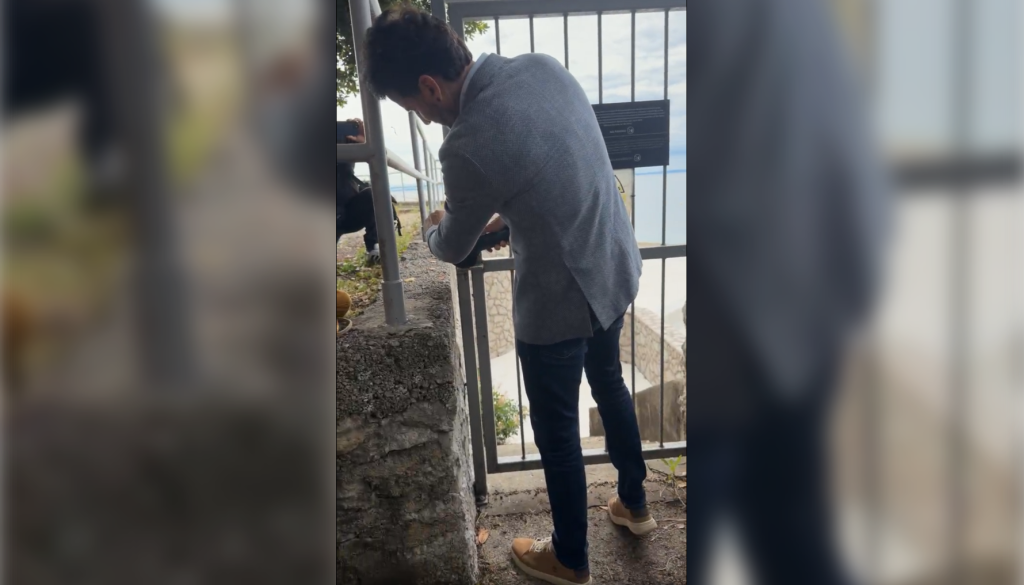 VIDEO: Poslanec pred kamerami z brusilko odstranil ključavnico na poti do plaže