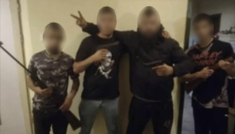 Mladi Romi iz Dolge vasi se hvalijo in pozirajo z orožjem