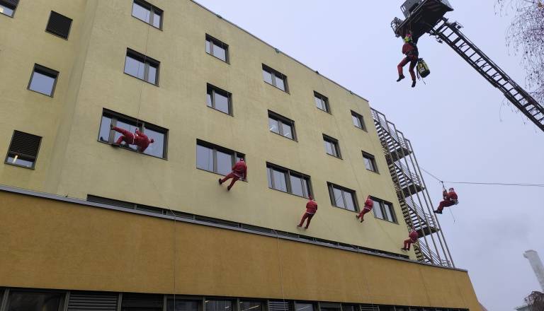 FOTO in VIDEO: Že tradicionalni spust Božičkov s strehe UKC Maribor razveselil hospitalizirane otroke