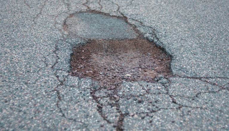 Poškodovano cestišče na Cesti v Prod, zaradi udarne jame ostala brez dveh pnevmatik