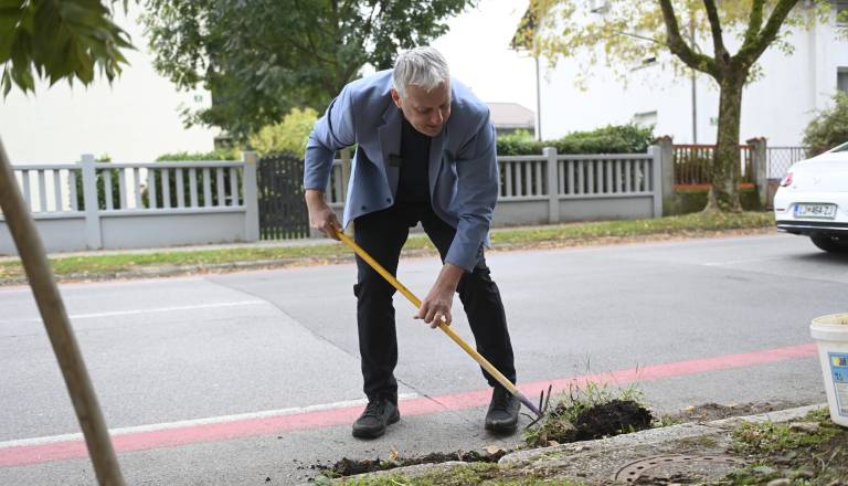 FOTO in VIDEO: Primc po vložitvi kandidature cestne odtoke čistil kar v obleki