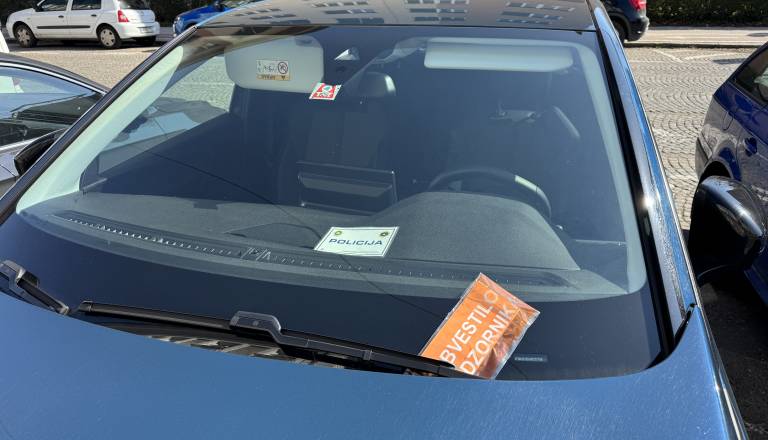 FOTO: Preiskovalci pred mariborsko občino, na službenih vozilih obvestila za nepravilno parkiranje.