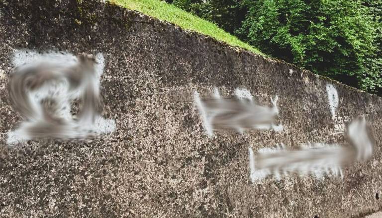 Vandali s političnimi grafiti oskrunili steno: Občina jih bo tam pustila do zaključka preiskave