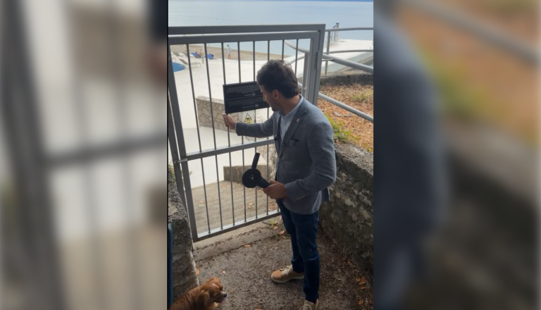 VIDEO: Poslanec v roke vzel brusilko in pred kamerami odstranil ključavnico na poti do plaže