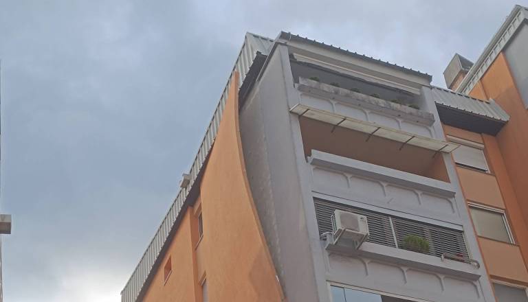 Po neurju na Planini s stanovanjskega bloka nevarno visi del fasade, na družbenih omrežjih se vrstijo očitki