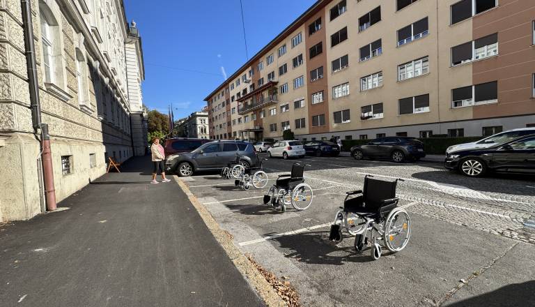 FOTO in VIDEO: Invalidski vozički namesto avtomobilov, kaj se dogaja pred mariborsko občino?