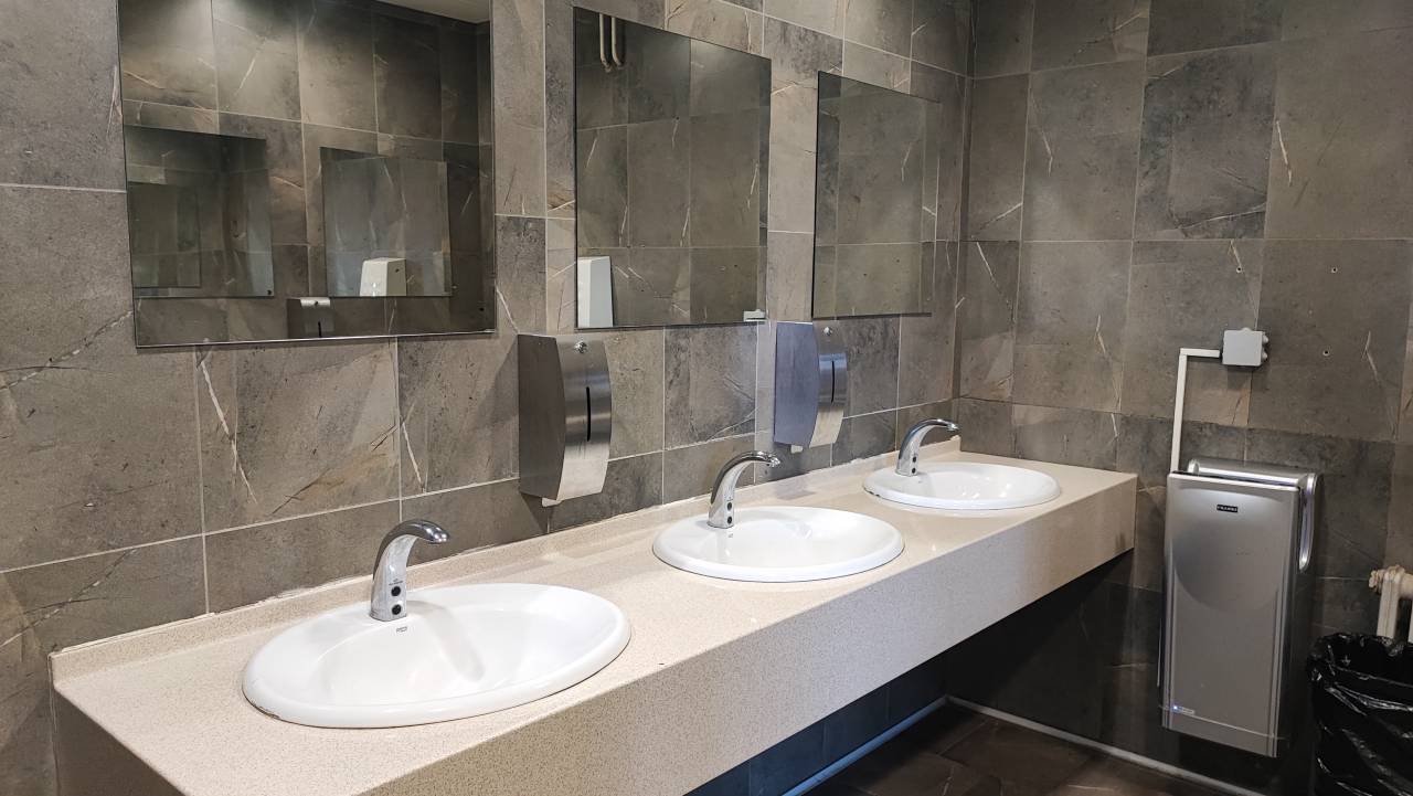 Lepo urejen predel stranišča z umivalniki. 