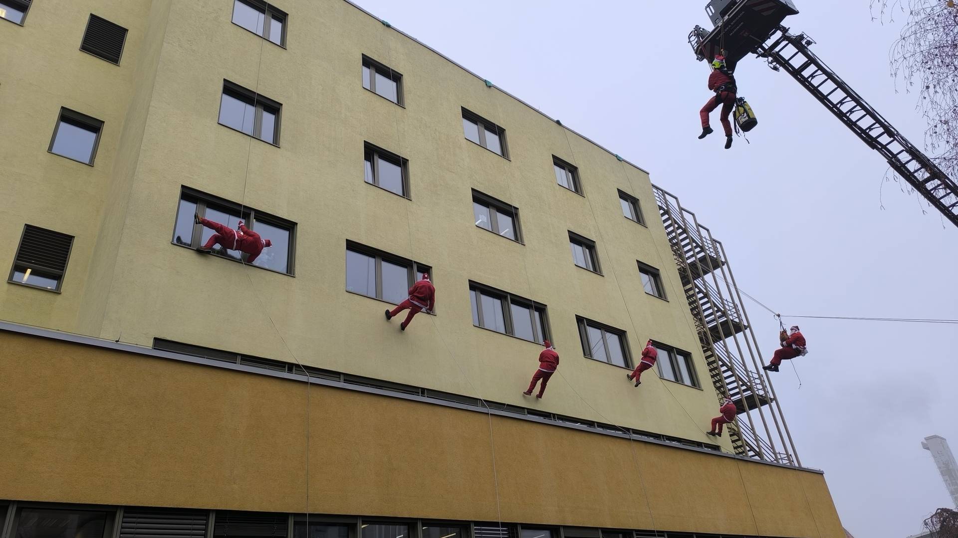 FOTO in VIDEO: Že tradicionalni spust Božičkov s strehe UKC Maribor razveselil hospitalizirane otroke