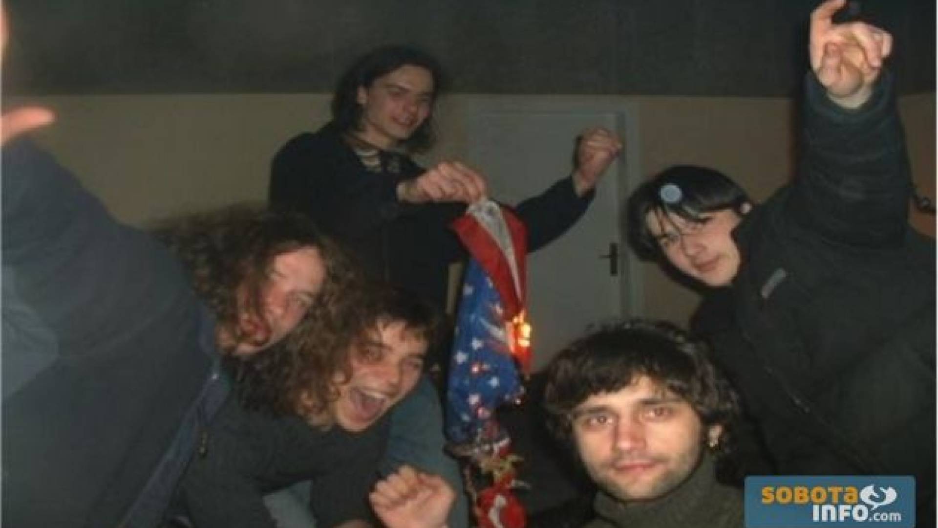 Vzhičena skupina obiskovalcev ANTI – NATO koncerta (15. marec 2003) z zažganim simbolom imperialne komande