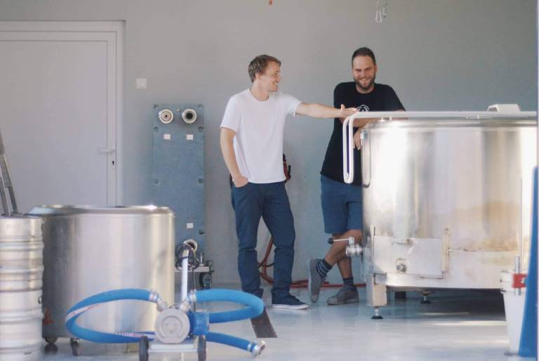 Ponosna očeta Rooster piva ob svojem 1000-litrskem kotlu.  