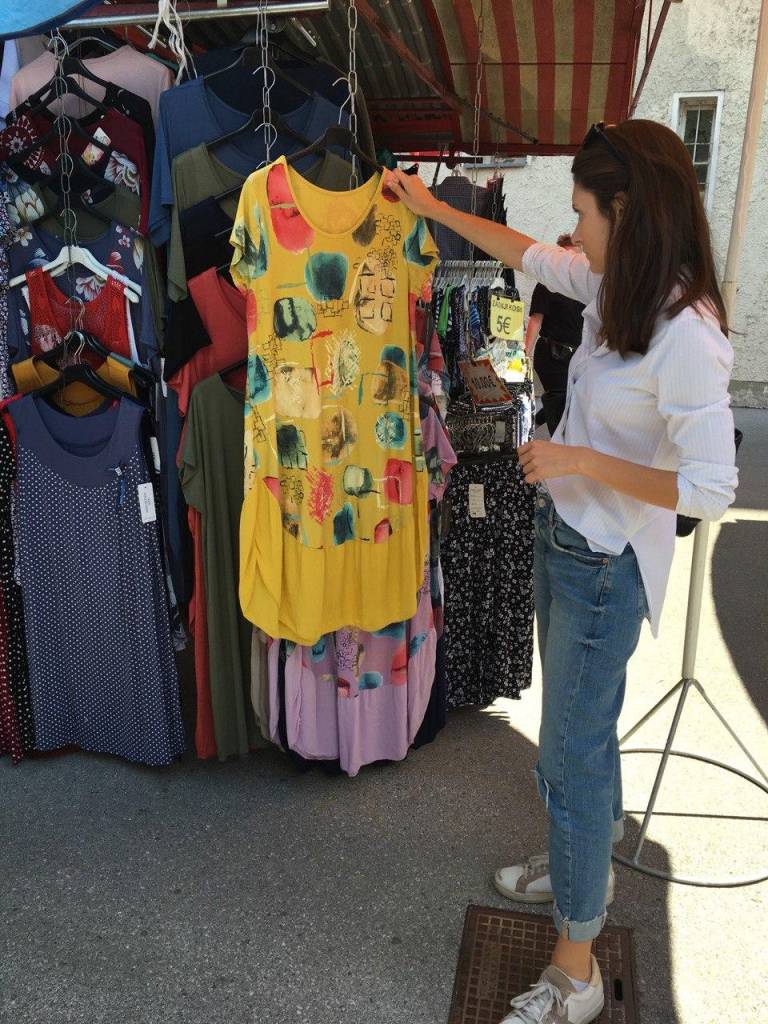 Oblačila kupujejo v Italiji in jih potem prodajajo na stojnici, pove ena izmed ponudnic. Med njihovimi kupci je ponavadi kar nekaj turistov, a to poletje je drugače. 