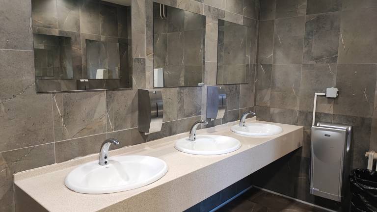 Lepo urejen predel stranišča z umivalniki. 